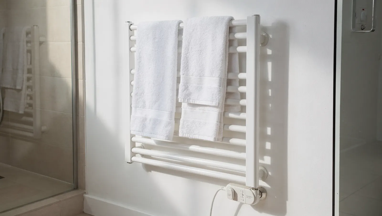 Sèche-serviettes électrique blanc avec des serviettes dans une salle de bain
